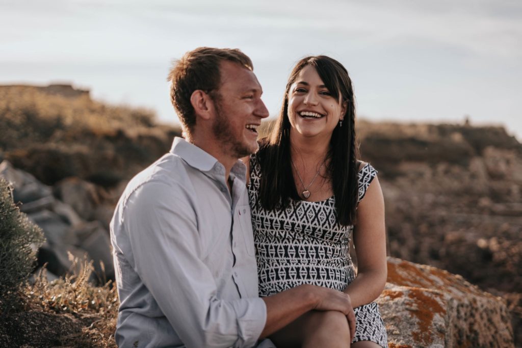 couple laughing and smiling on their engagement session in Guernsey
