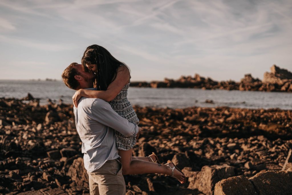 groom to be lifting bride to be and kissing