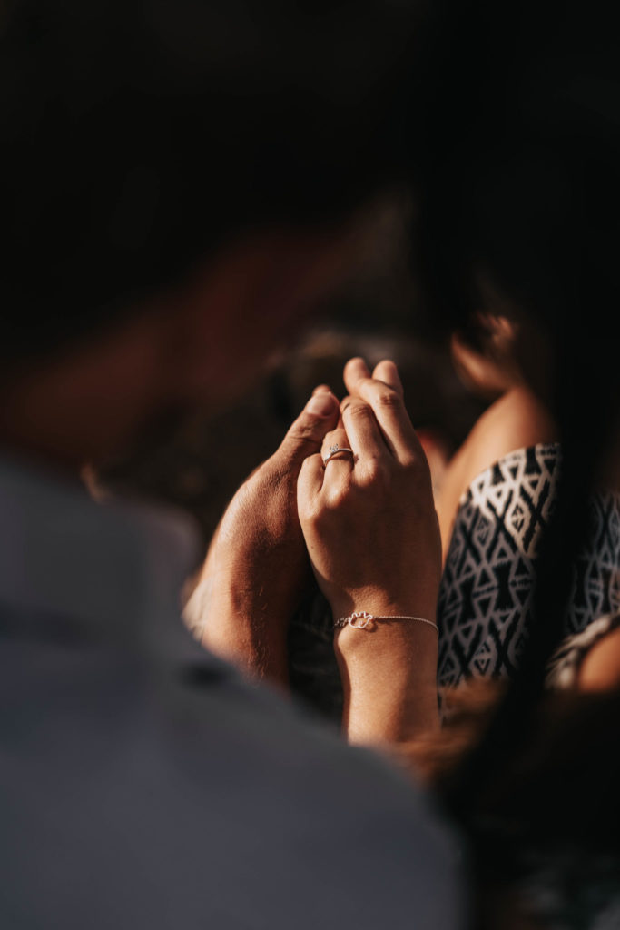 groom to be admiring his bride to be's engagement ring