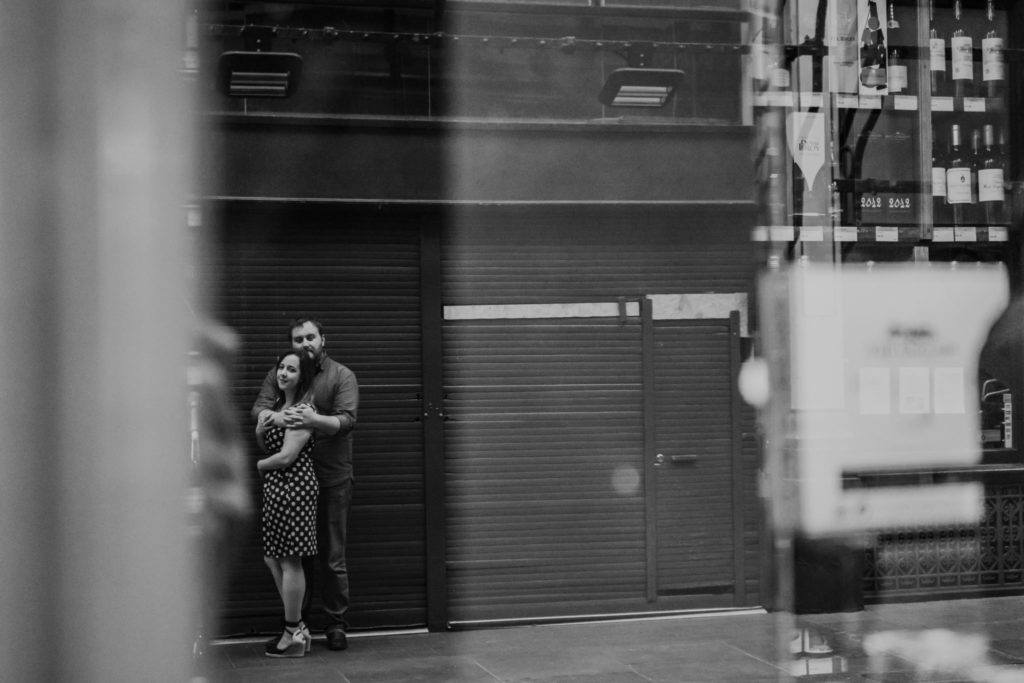 reflection in a shop window of couple hugging