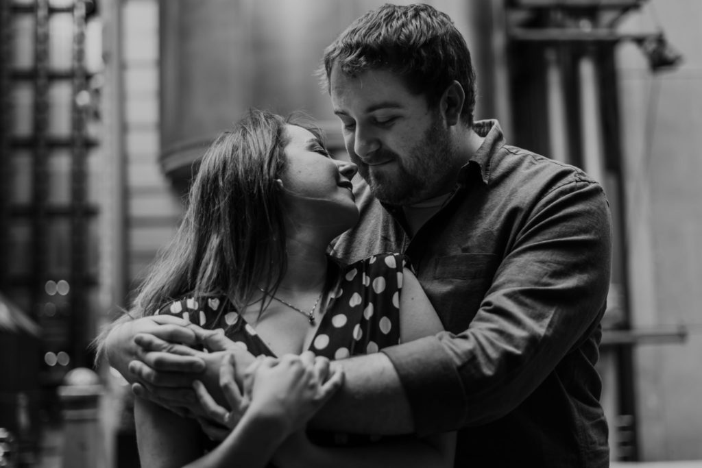 bride to be in groom to be's arms about to kiss