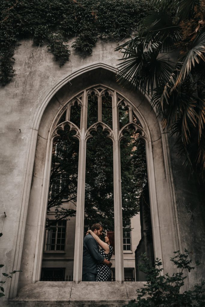 view of couple hugging through window of abandonned church