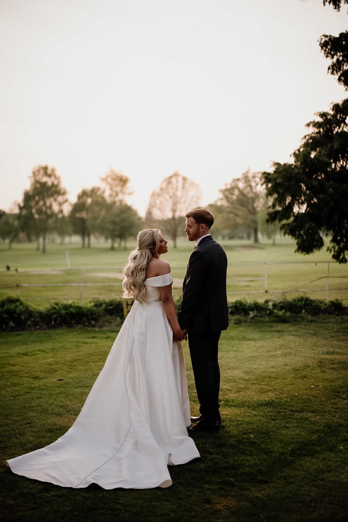 Golden hour photo of bride and groom softly embracing after their wedding reception captured by Suffolk Wedding Content Creator The Unscripted