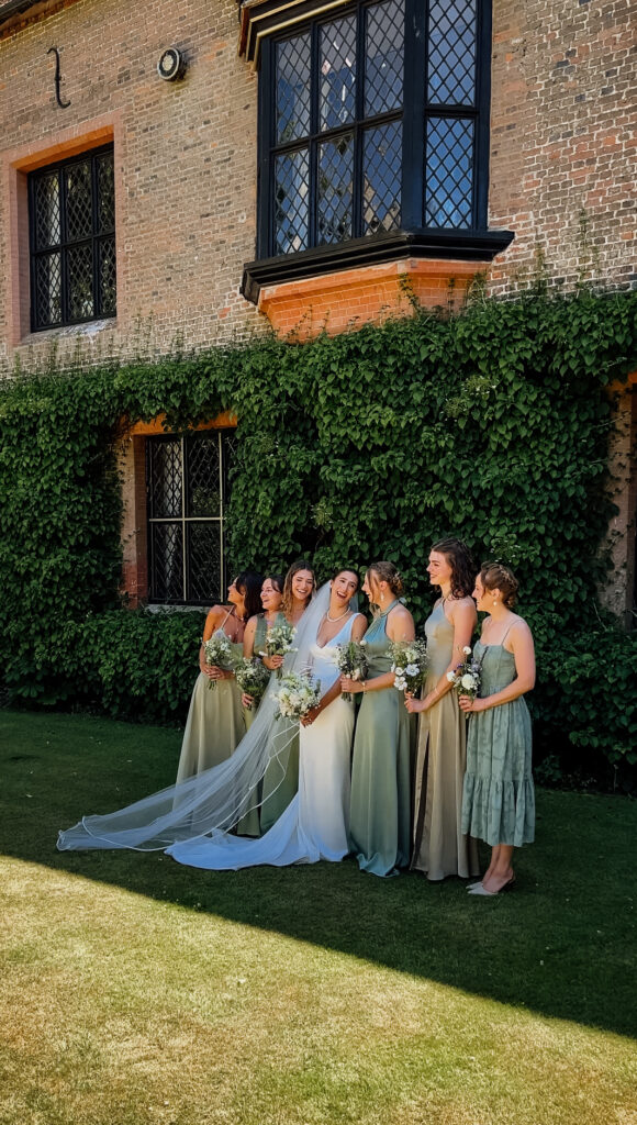 Bride laughing with her bridesmaids during group photos captured by wedding content creator in Suffolk