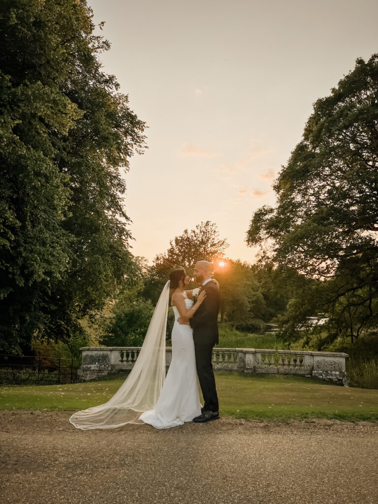 Couple walking through Braxted Park gardens at sunset captured by Essex Wedding Content Creator